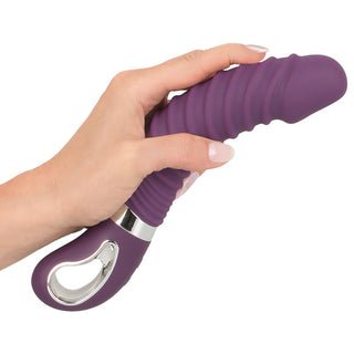 Wärmender Soft Vibrator in Lila in einer Hand gehalten