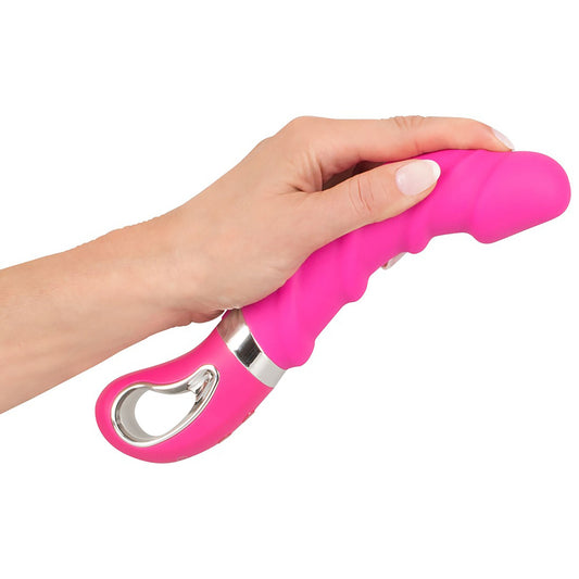 Wärmender Soft Vibrator in Pink in einer Hand gehalten
